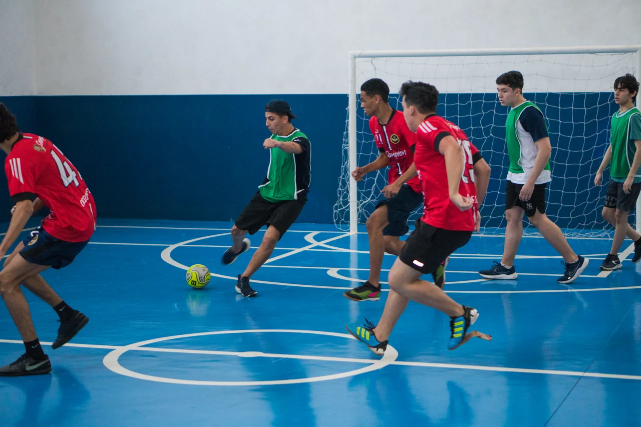 Alunos jogando futsal na quadra poliesportiva do Octagon