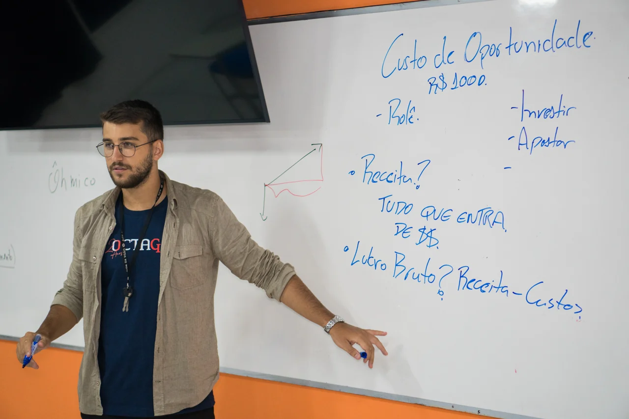 Professor do Octagon explicando uma atividade no quadro em sala de aula